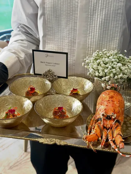 Black Pepper Lobster, presented in ornate golden bowls on a silver tray, with a whole lobster as a stunning display piece.