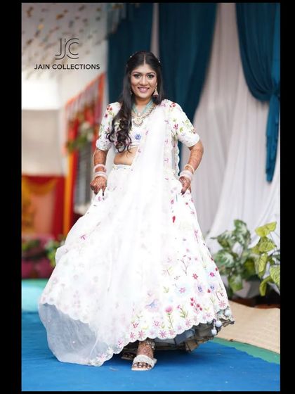 A client twirling in a white floral lehenga, looking fresh and beautiful for a daytime event.