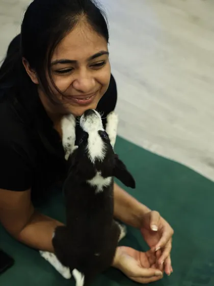 A participant gets a sweet puppy kiss while lying on her yoga mat. These are the moments of pure connection that make our puppy yoga events in Chennai so special for both humans and animals.