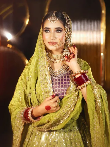 This Walima look is all about regal elegance. I focused on creating a flawless, luminous base to complement the stunning olive and purple attire. The makeup features dramatic smokey eyes, contoured cheeks, and traditional jewelry like the passa and nath for a complete, breathtaking bridal look.