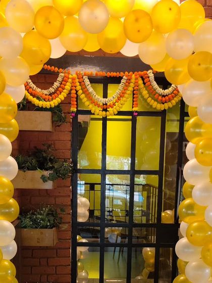 A traditional marigold garland adds a classic touch to the balloon arch entrance for this 60th birthday celebration.
