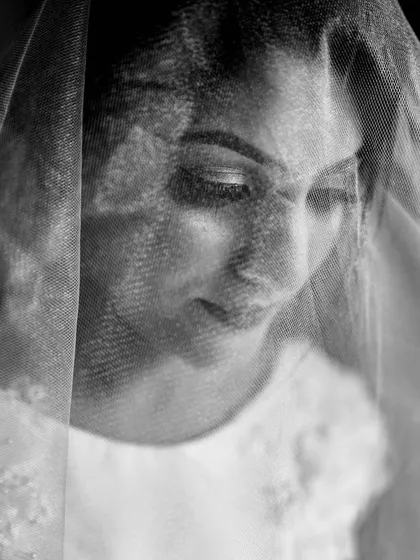 A close-up black and white portrait of a bride seen through her veil. I manually focused on her eyelashes to create a soft, dreamy, and intimate photo that highlights her delicate features.