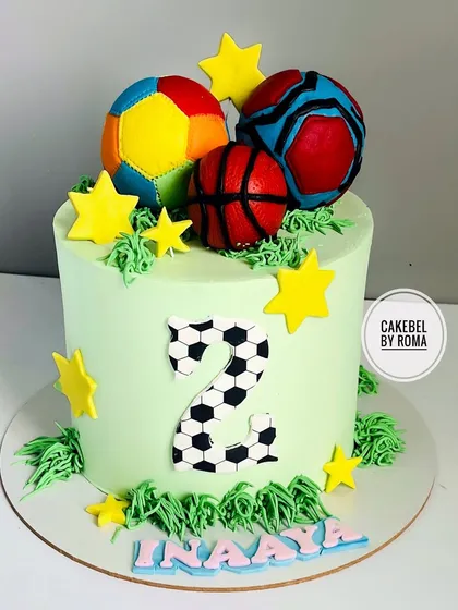 A sports-themed cake for Inaaya's 2nd birthday. This cake celebrates her love for all kinds of balls, with fondant creations of a football, basketball, and volleyball.