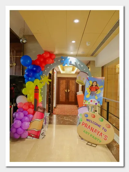 A creative Art Party entrance arch, decorated with giant crayon and paint tube cutouts, welcoming guests to Pranaya's celebration.