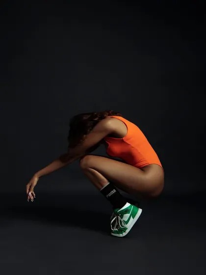 A dynamic, coiled pose that suggests potential energy. It's an artistic take on athletic movement.
