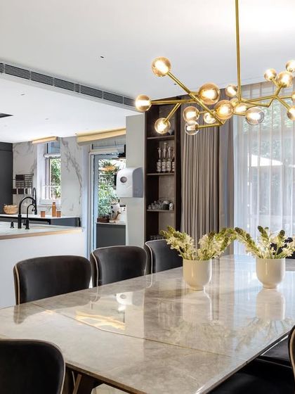 The AMARA project features a Nordic-inspired open-plan kitchen and dining area. A large island with a breakfast bar encourages social cooking, while the elegant dining table is perfect for family meals, all bathed in natural light.