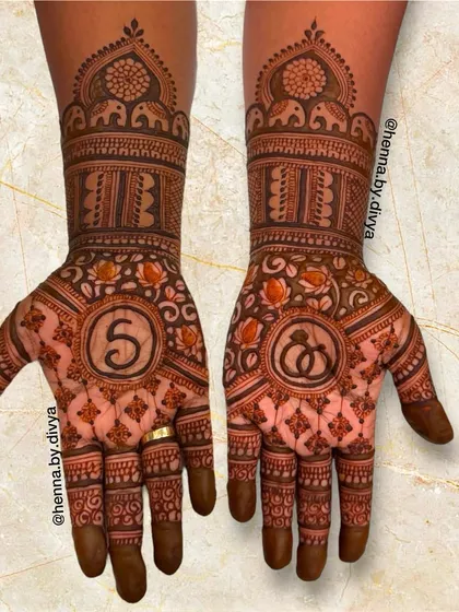 A traditional engagement mehendi with the initial 'S' and an engagement ring symbol. The design is filled with classic elephant motifs and jaali (net) patterns.