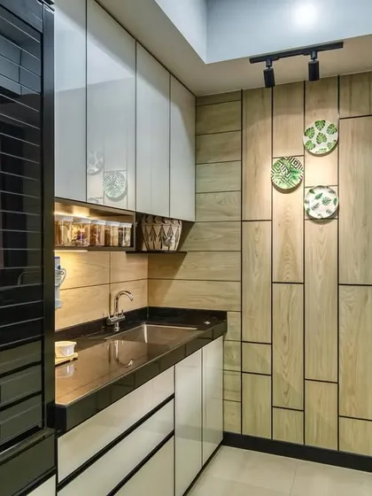 A view of the sink area in the Lodha Park kitchen, with a stylish black faucet and open shelves for easy access.