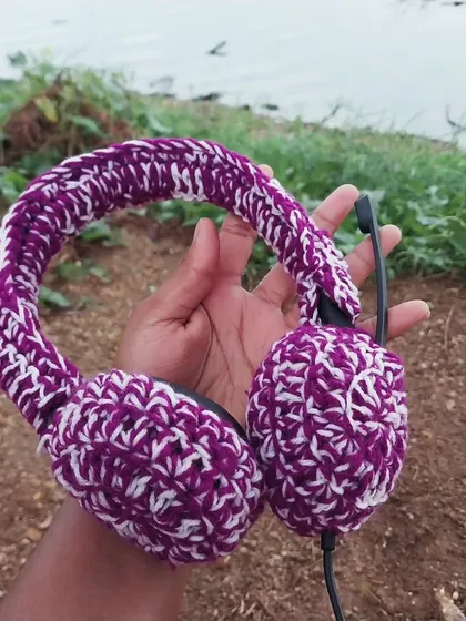 A close-up of the crochet headset cover, showing the texture and how it fits snugly over the headphones.