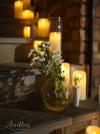 A close-up of a small floral arrangement and candles on a wooden staircase, showing how even small corners can be made beautiful.