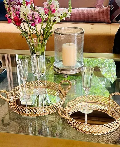 Here, our gold mirror trays are used to create an elegant vignette on a coffee table, holding champagne flutes and a hurricane lamp. They are perfect for serving drinks or simply elevating your decor.