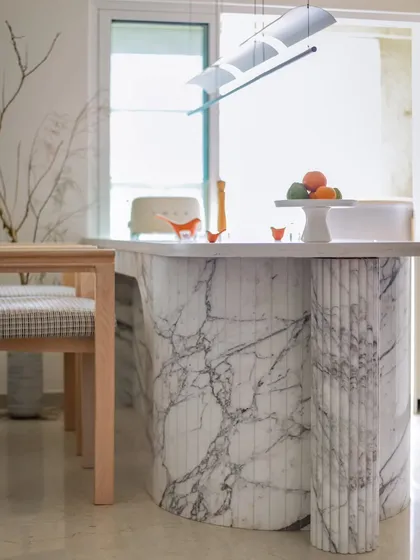 Another view of the marble-clad breakfast counter, showcasing its elegant curves and the beautiful fluted detailing on the support column.