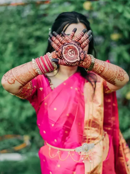 A classic pose that highlights the circular mandala design on the palms, a popular choice for engagements.