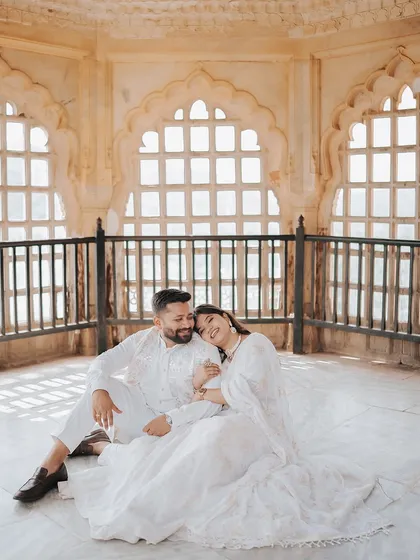 A serene moment of the couple sitting together inside a beautifully lit chamber in Amer Fort, capturing a feeling of peace and intimacy.