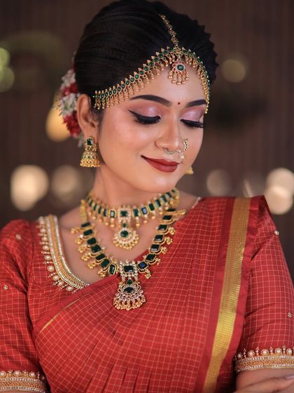 Model Swetha in a red checked silk saree. This traditional drape is perfect for showcasing classic South Indian bridal looks for catalogues or campaigns.