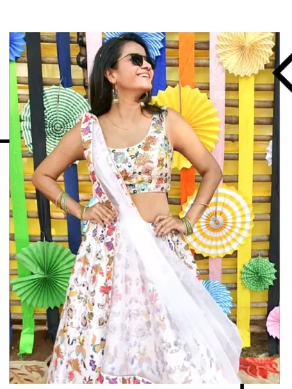 Another shot of our client looking stylish and happy in the white floral lehenga. It's a versatile outfit that's perfect for any pre-wedding celebration.