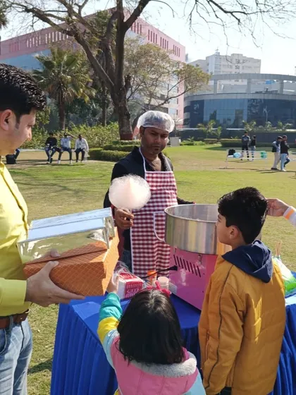 My staff serving freshly made cotton candy to children at a family day event. These food stalls are a perfect addition to any party or carnival.