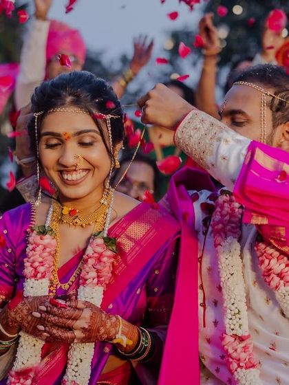 A happy moment during a Maharashtrian wedding ceremony, with the couple surrounded by cheering family.