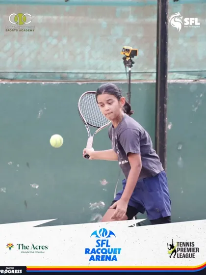 A young girl focuses intently on the ball, demonstrating excellent forehand technique. In the background, our AI camera captures the action for post-match analysis.