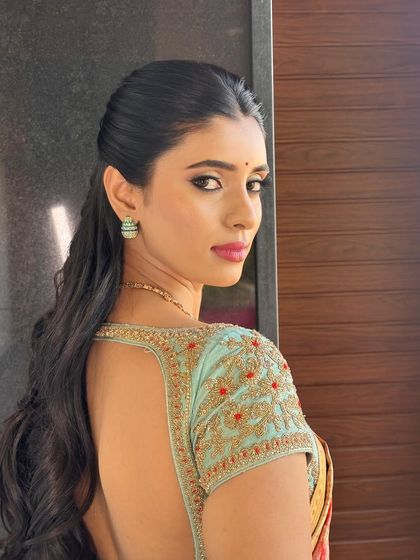 A back view of a client's blouse, showing off the deep back and the intricate hand embroidery on the sleeves.