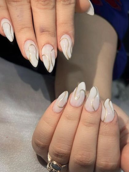 An elegant and minimalist design with a milky white base and delicate gold swirl lines.