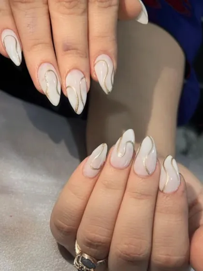 An elegant and minimalist design with a milky white base and delicate gold swirl lines.