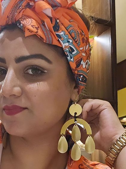 A close-up on my festival earrings. These danglers have a modern, artistic feel that perfectly complements the bohemian vibe of my outfit.