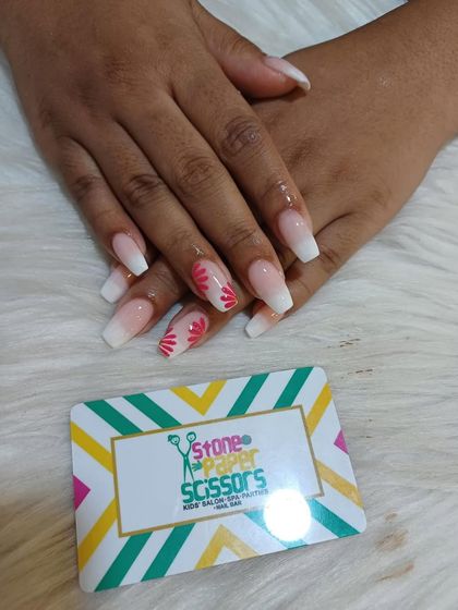 A soft and pretty set combining a white ombre effect with a delicate pink floral design on the tips of the accent nails. It's a beautiful blend of two popular styles.
