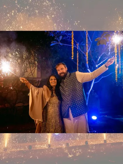 A happy couple celebrating Diwali with sparklers, a classic shot full of festive joy.