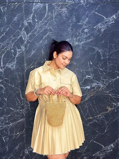 This is my mini straw bucket bag, a cute and trendy accessory for a sunny day. Its compact size and woven texture make it a perfect match for a light, summery dress.