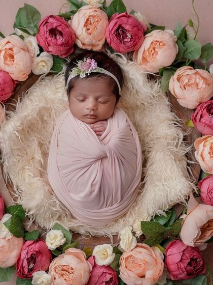 A sleeping beauty surrounded by peonies. The simple, snug swaddle allows the baby's peaceful face and the beautiful floral wreath to be the stars of the photo.