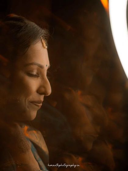 A creative, low-light portrait of a bride using a ring light to create dramatic shadows and highlights, emphasizing her serene expression.