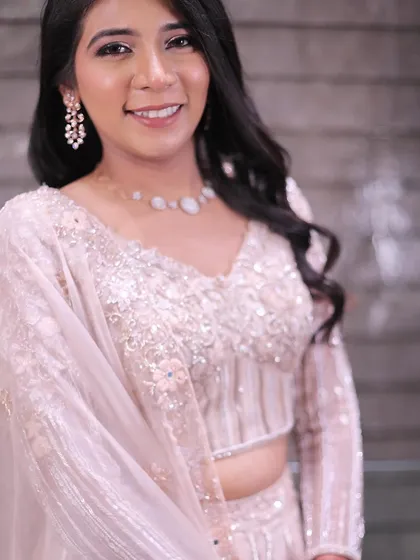 A close-up of the bride's happy smile. The makeup is focused on creating a fresh, dewy complexion with a soft pink lip that enhances her natural beauty.