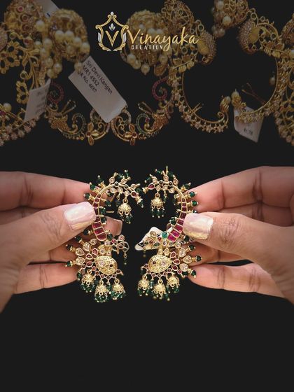 These celebrity-style earcuffs feature a beautiful peacock design with ruby and emerald colored stones and tiny jhumki drops. They are perfect for making a fashion statement.