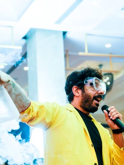 A science show performer, complete with safety goggles, amazes the crowd with a smoking concoction during an educational and fun segment.