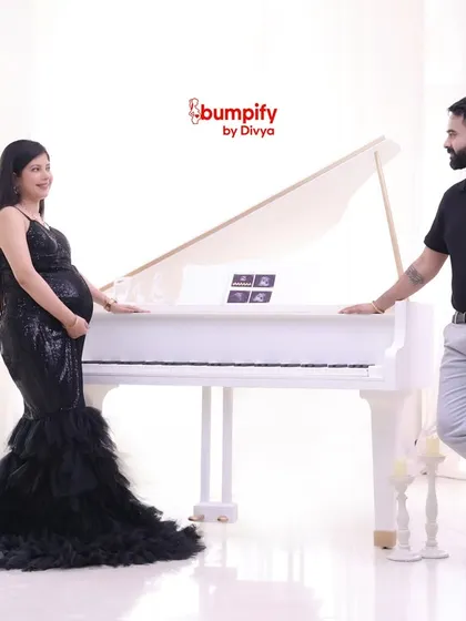 The couple poses with the grand piano. This setup is perfect for creating luxurious and memorable maternity portraits.