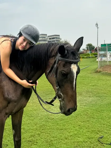 A rider gives her horse a hug after a lesson in the field. The bond is the most rewarding part of the journey.