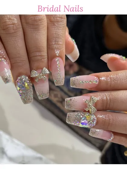 For our brides, we create unforgettable nail art. This design features long, square-shaped extensions with a glitter base, sparkling rhinestones, and delicate 3D bow embellishments for a truly special day.