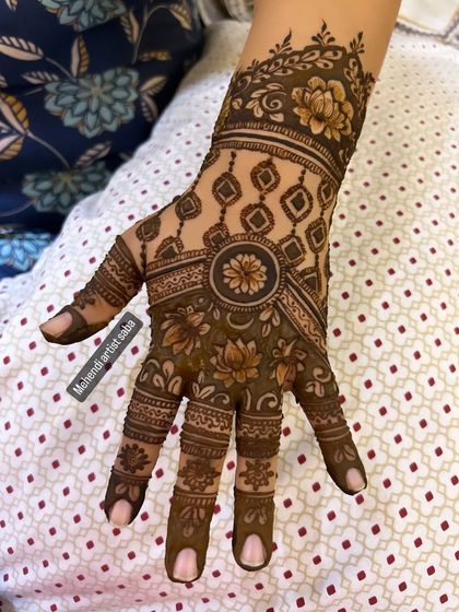 A single hand showing a beautiful and neat design for an engagement. The central mandala and detailed fingers are classic and elegant.