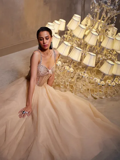 A seated portrait in the Bella Gown, allowing the full expanse of the soft tulle skirt to create a dreamy, romantic frame around the structured, embellished corset.