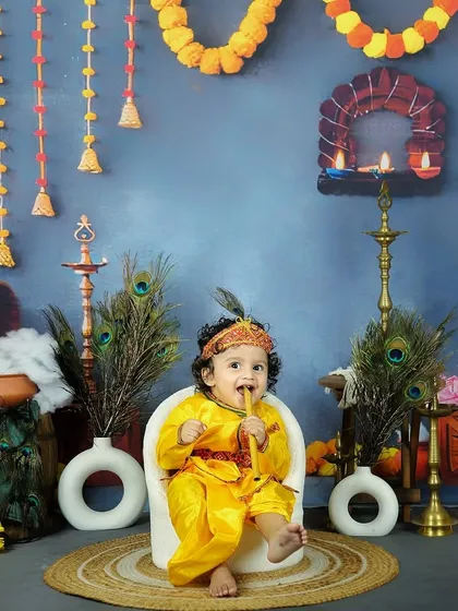 A playful moment during the Krishna-themed shoot, where our little model is enjoying his flute. The detailed set helps create an authentic and festive atmosphere.