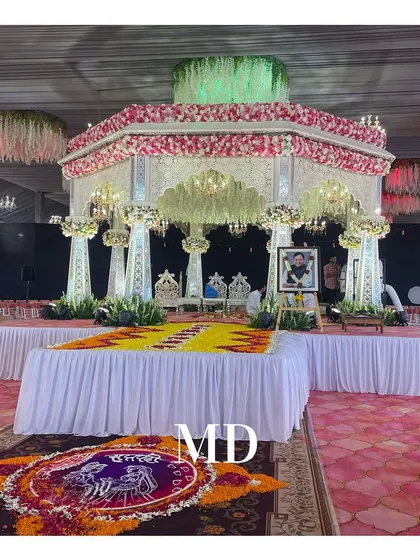 A beautiful Vidhi Mandap setup for a Haldi ceremony. The design incorporates a traditional floral canopy, elegant seating, and a custom rangoli made of fresh flower petals.