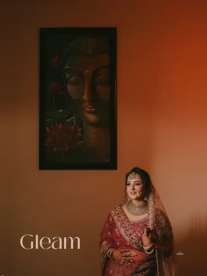 A serene bridal portrait, with the bride seated gracefully. The warm lighting and the Buddha painting in the background create a calm and spiritual ambiance.