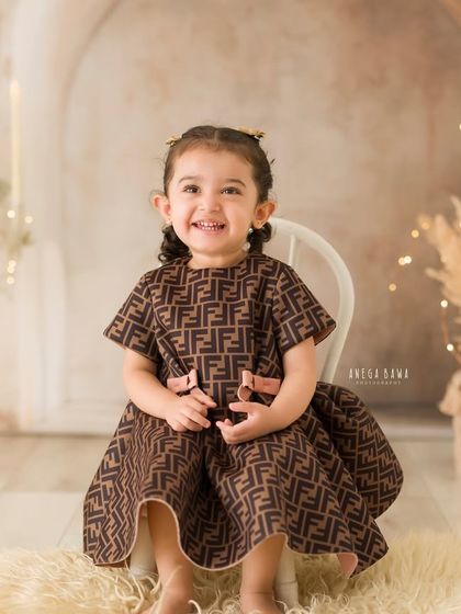 A full, happy smile from a little girl during her solo portrait session. The warm, festive background adds a touch of magic.