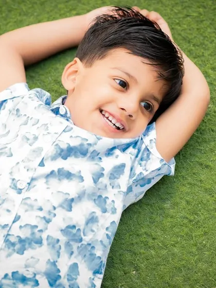 A relaxed and happy outdoor shot of a boy lying on the grass. These sessions are all about capturing genuine, carefree moments.