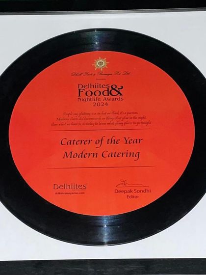 A close-up of the 'Caterer of the Year 2024' award plaque, designed like a vinyl record.