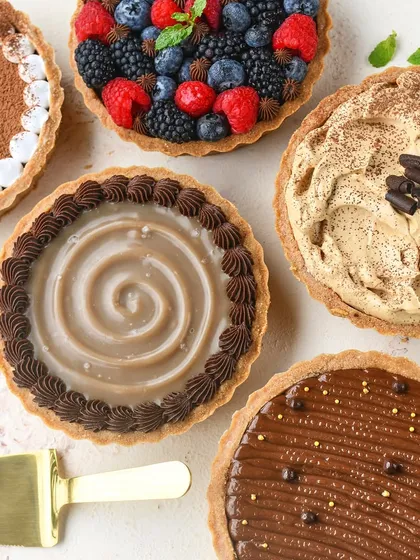 My Signature Chocolate Tarts are a highlight of my festive menus. This overhead shot shows the variety of gourmet toppings available, from fresh berries to coffee mousse and salted caramel.