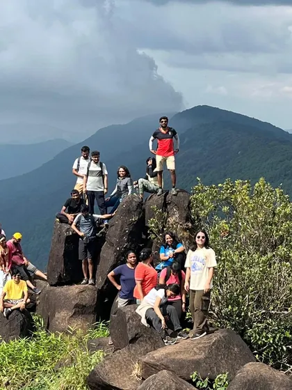 The full group posing on the rocks at the summit.