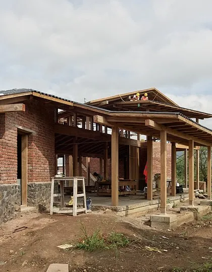 The structure of the Kamshet farmhouse, with its brick walls and timber frame, is captured here during construction. The design emphasizes natural ventilation and shaded spaces, crucial for comfort in the local climate.