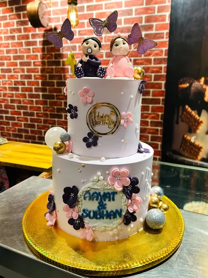 The full view of the lavender-themed first birthday cake for twins Aayat and Subhan.